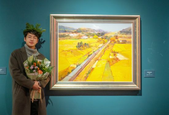 朱國舉在畫作《穿越金秋田野》前留影。